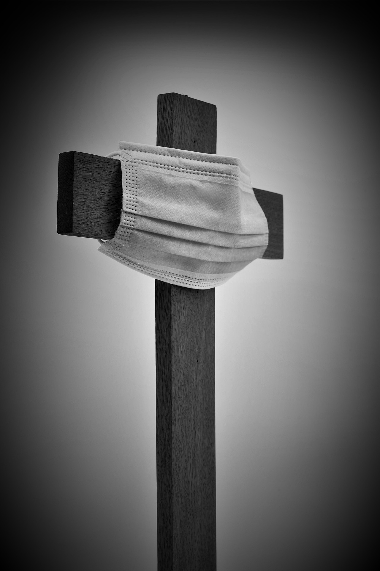 Una croce religiosa associata a una mascherina in tempo di pandemia