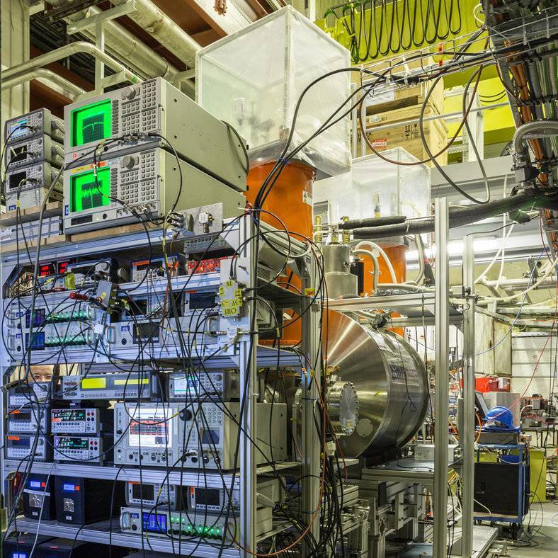 L'esperimento BASE (The Baryon Antibaryon Symmetry Experimen) presso il CERN di Ginevra: sono visibili gli armadi elettronici o rack, il magnete orizzontale della Trappola di Penning e i criostati arancioni (Foto: CERN)