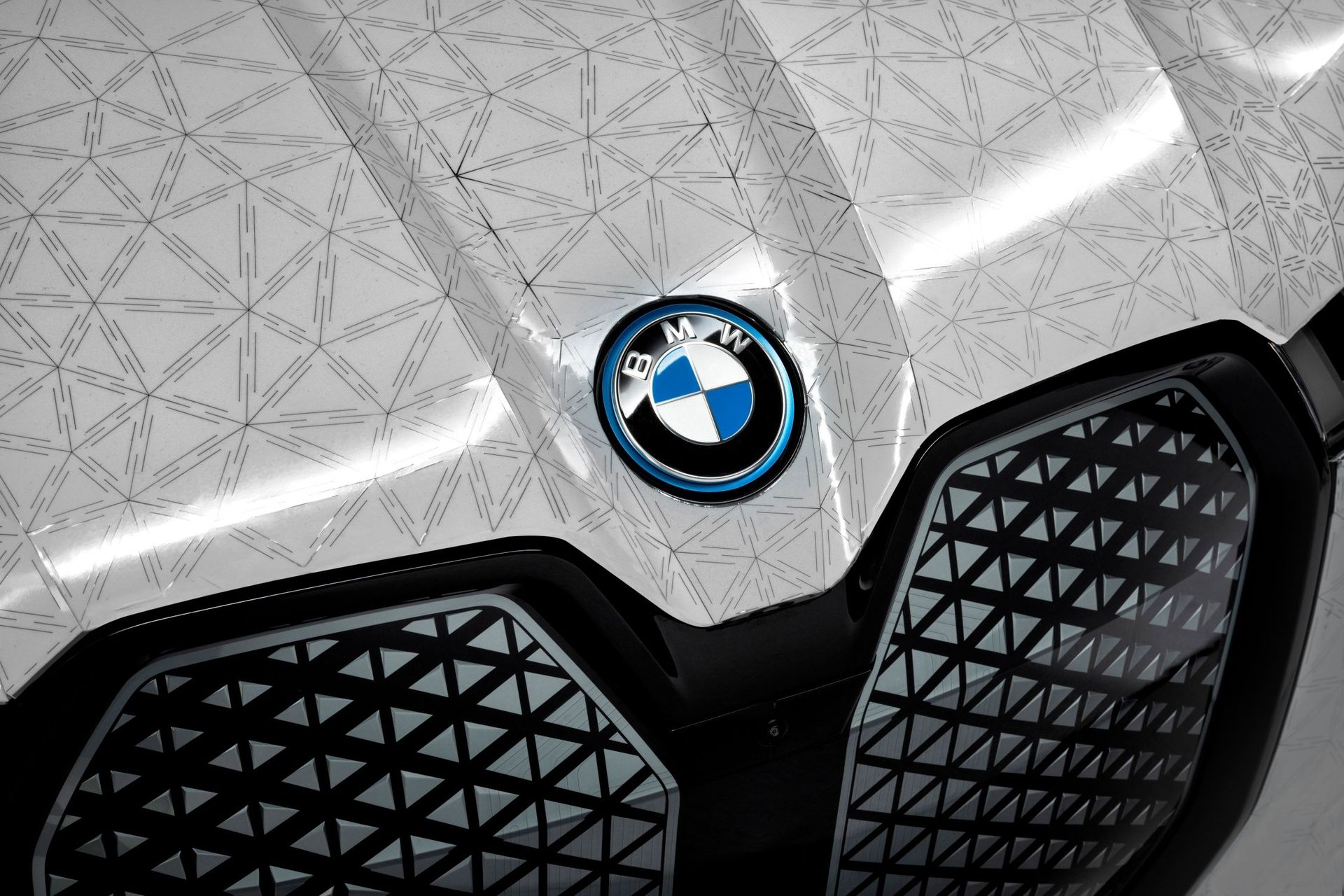 Деталь носовой части ультрароскошного iX Flow: по запросу электрического импульса электрофоретическая технология, созданная BMW в сотрудничестве с E Ink, выводит на поверхность различные цветовые пигменты, придавая кузову желаемый цвет