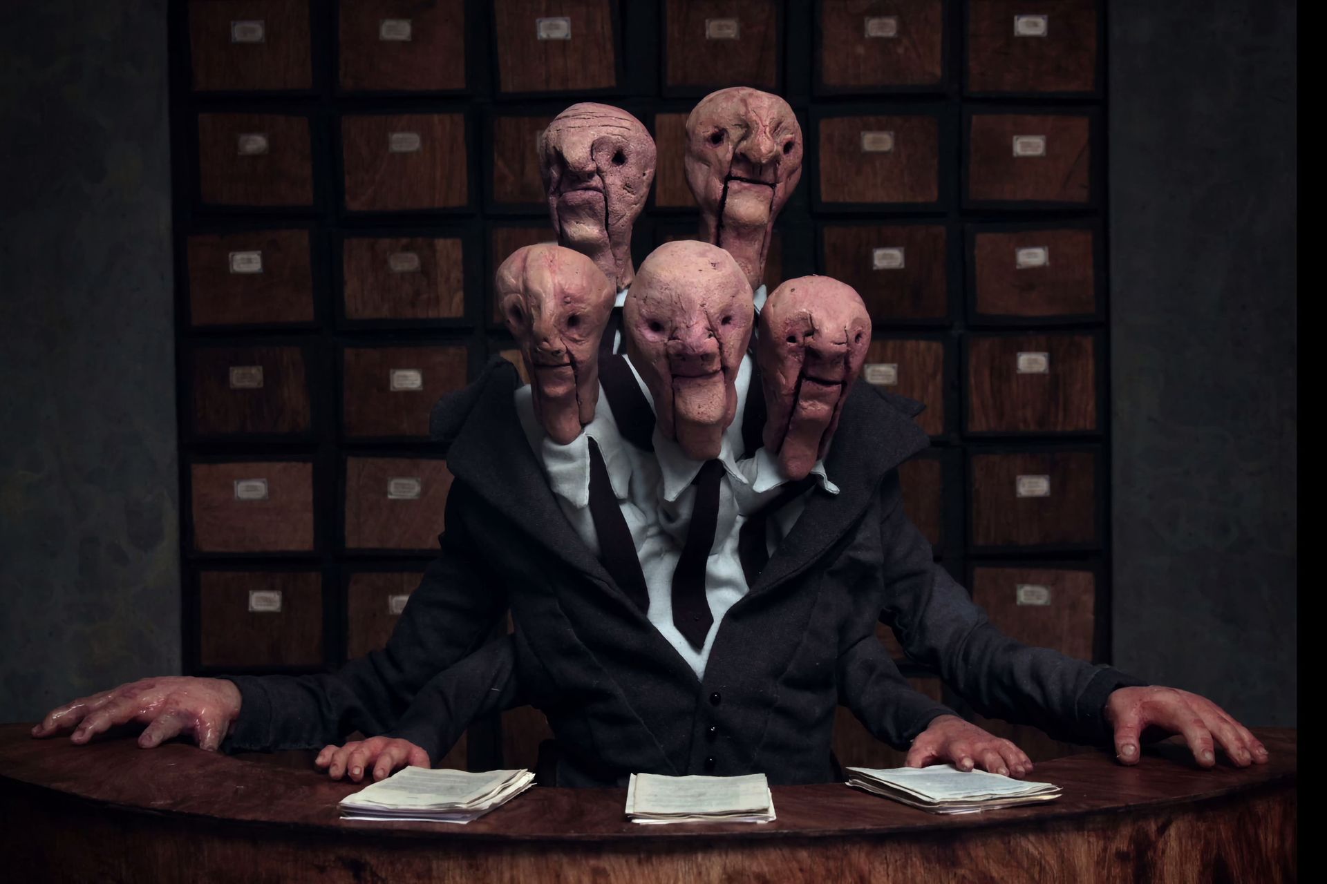 Una representación del monstruo burocrático de cinco cabezas y cuatro manos.