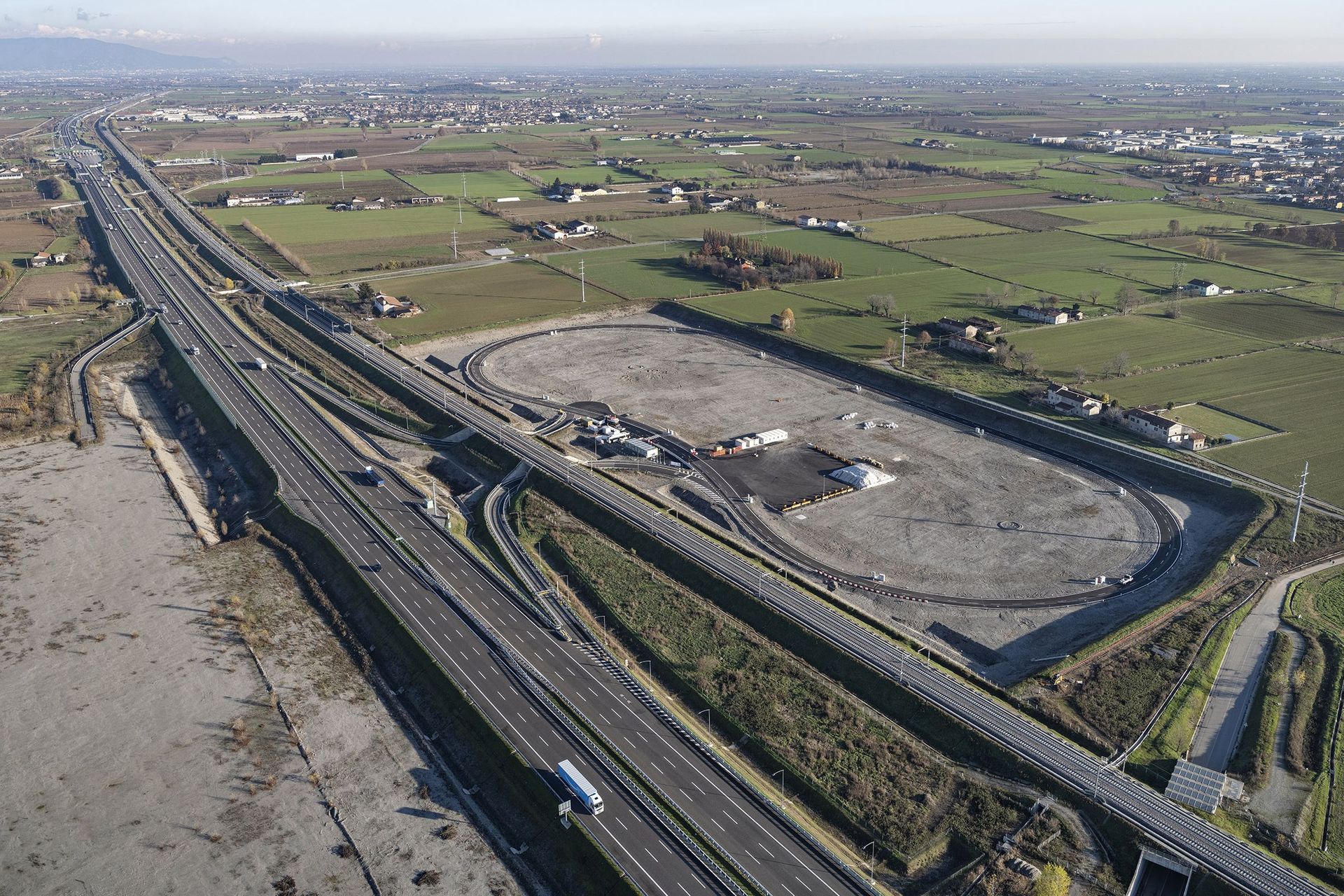 "Framtidens arena" i Chiari, i Brescia-provinsen Lombardiet, i slutet av byggnadsarbetena: det är en innovativ ringkrets, nära motorvägen BREBEMI A35, på vilken induktionsladdning av elfordon testas, som färdas på dedikerade körfält under vilka spolar är placerade