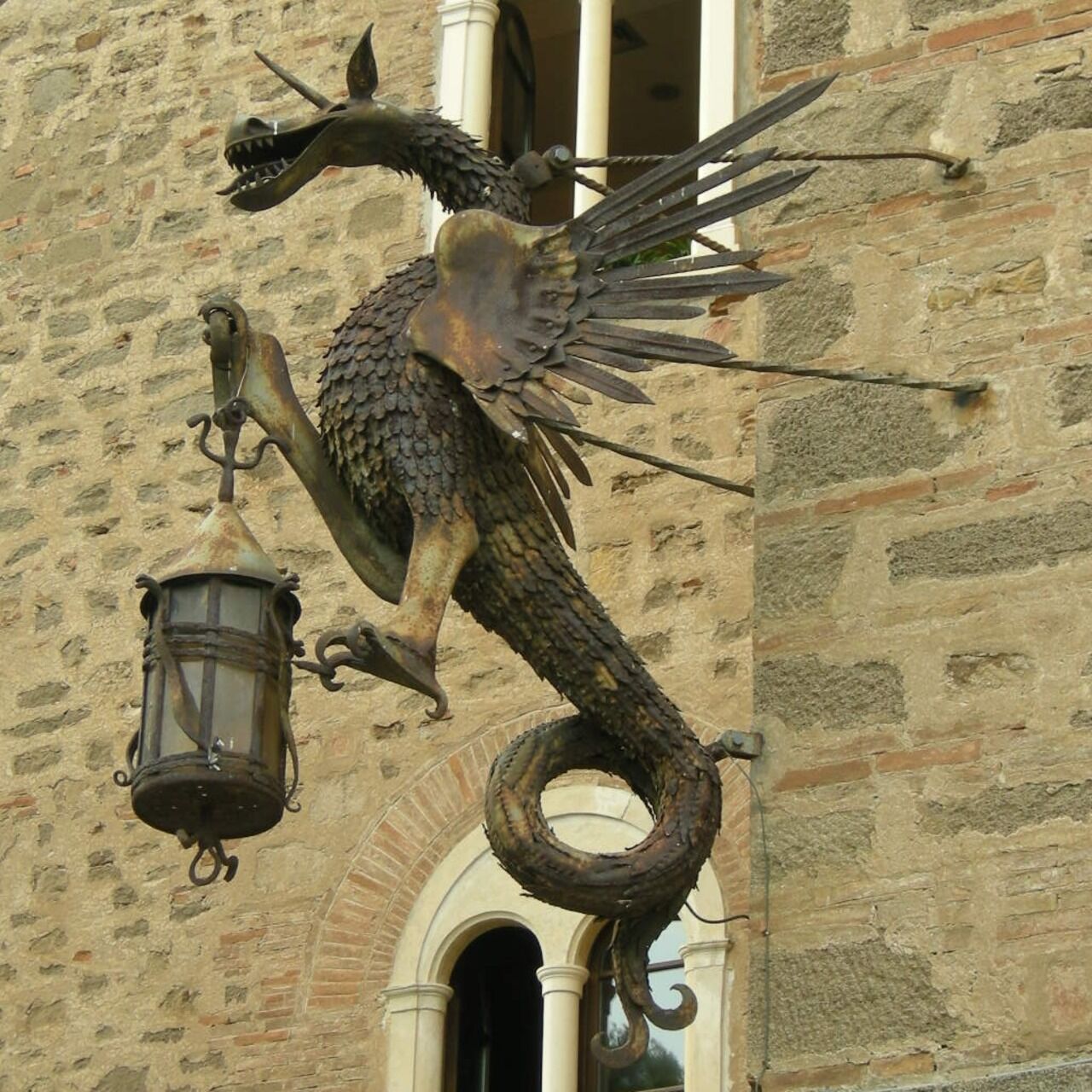 Il dragone portafiaccola sulle mura di Castello Pasquini a Castiglioncello di Rosignano Marittimo