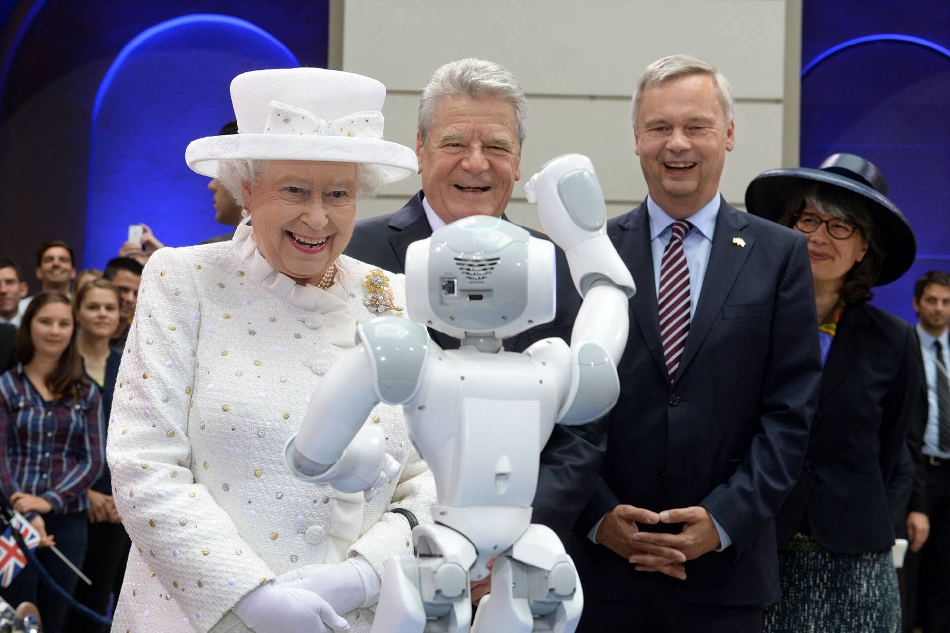 La Regina Elisabetta II a contatto con un piccolo robot durante una visita a Berlino