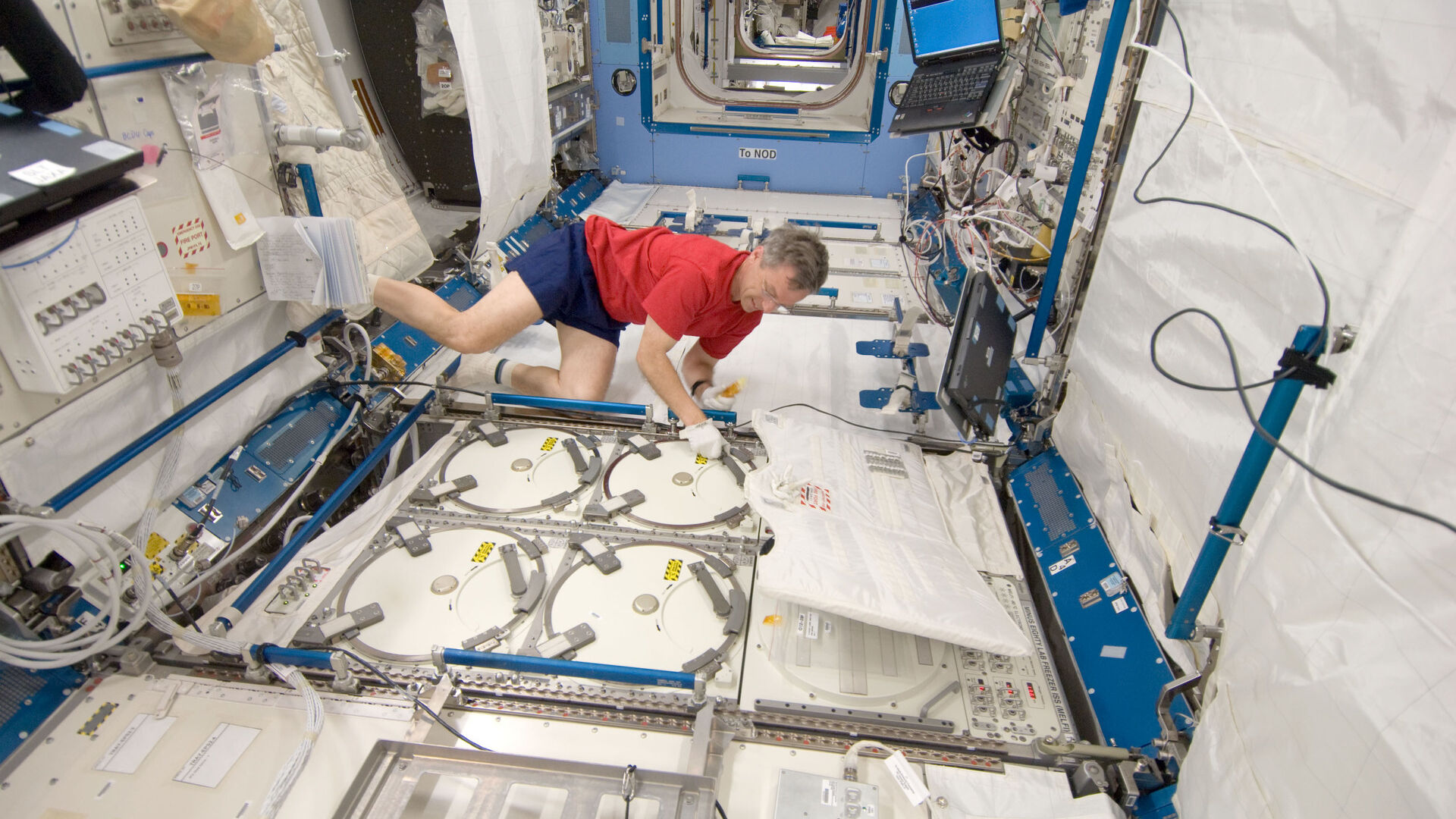 L’astronauta Robert Thirsk alle prese con campioni di materiale destinato ad esperimenti presso il congelatore del laboratorio della Stazione Spaziale Internazionale a meno ottanta gradi