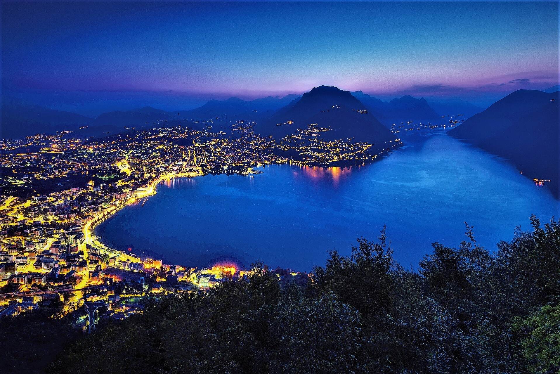Ente Turistico del Lugano: staden Lugano i kantonen Ticino sett från Monte San Salvatore