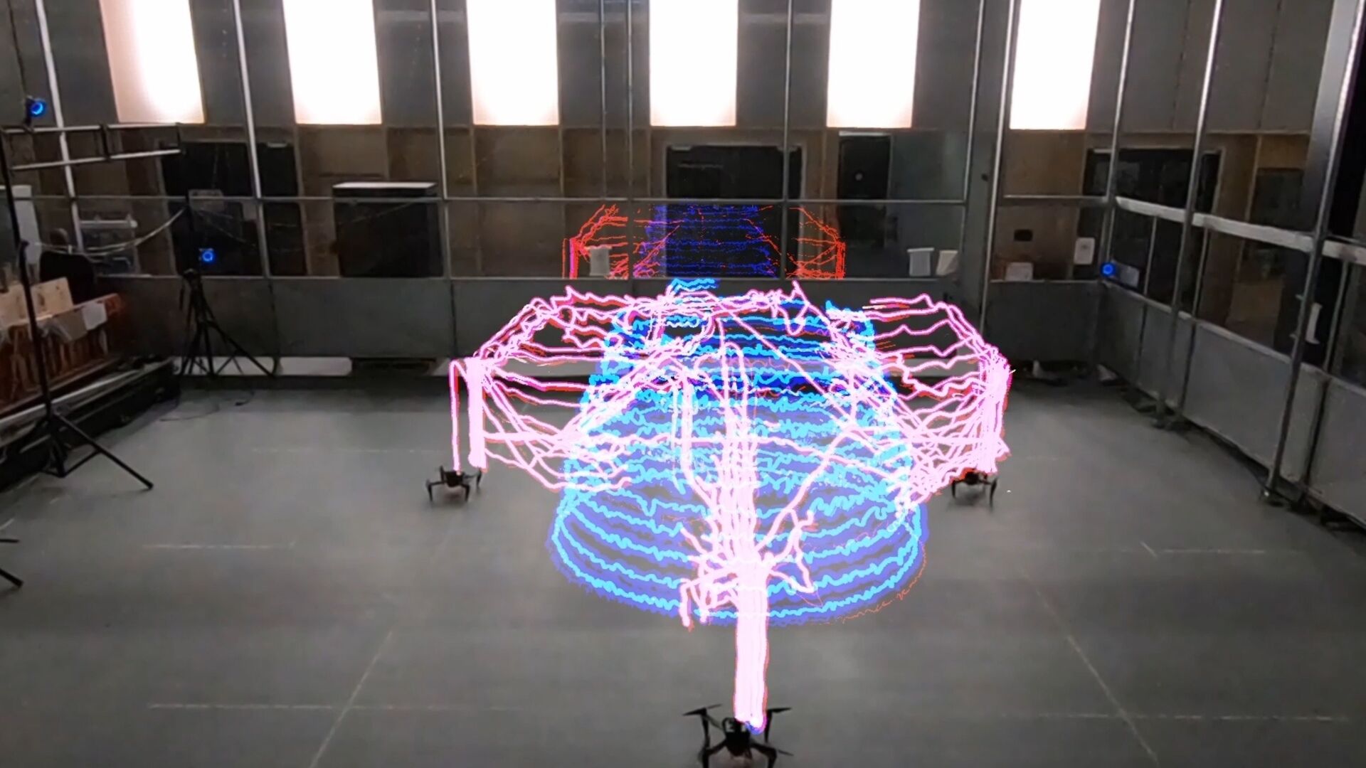Droni collaborativi: una traccia luminosa in timelapse che dimostra la coordinazione multi-agente del team di robot Aerial AM