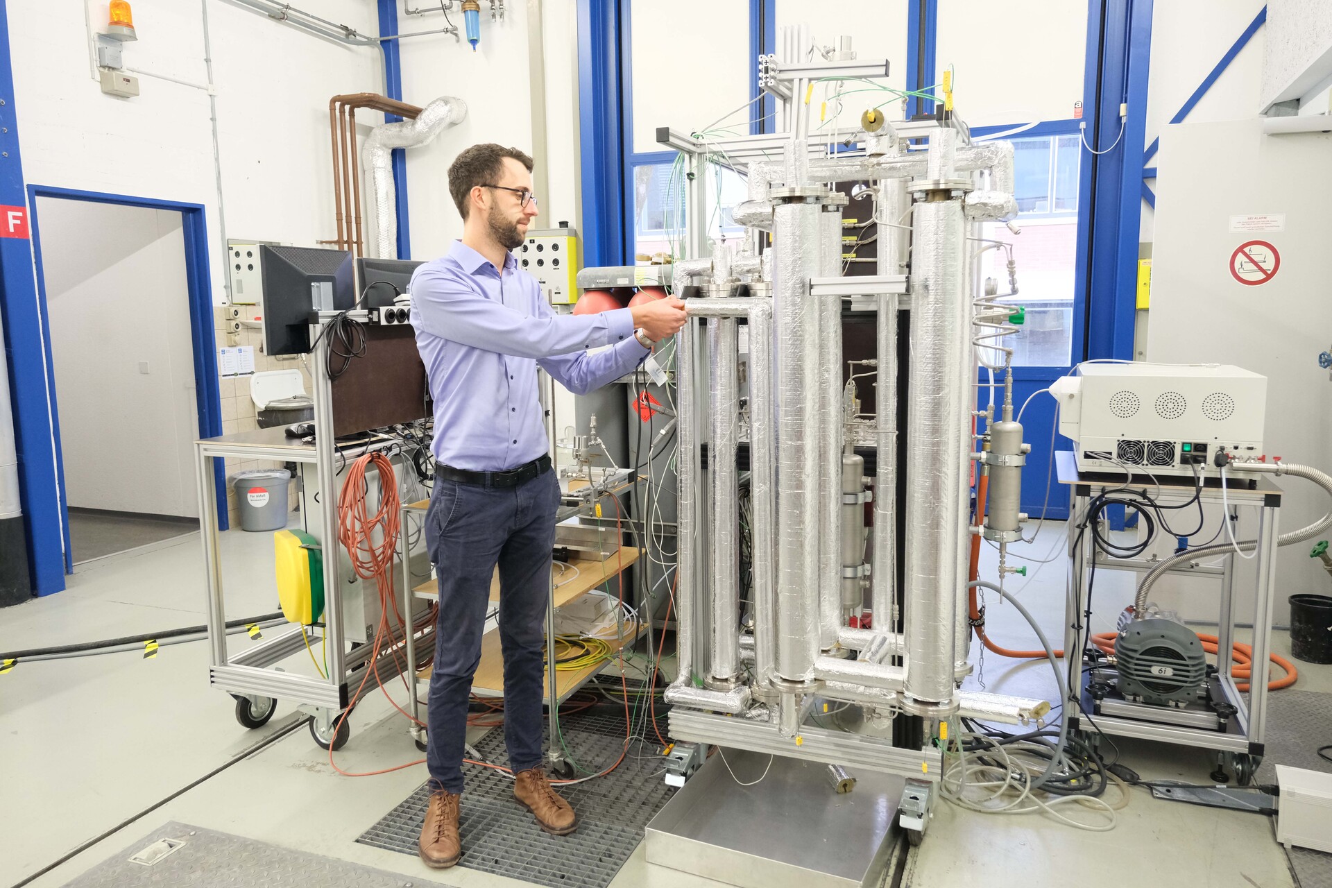 Syntetisk metan: resultater av det nye reaktorkonseptet kan implementeres for storskala anlegg: Florian Kiefer, prosjektleder for metanering med absorpsjon ved EMPA, ved siden av testanlegget (Foto: EMPA)