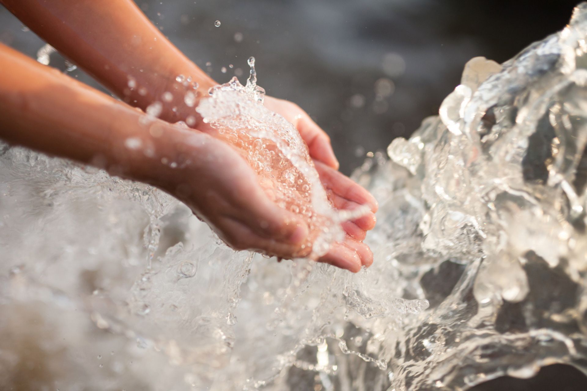 Acqua: mani raccolgono l'acqua di una cascata