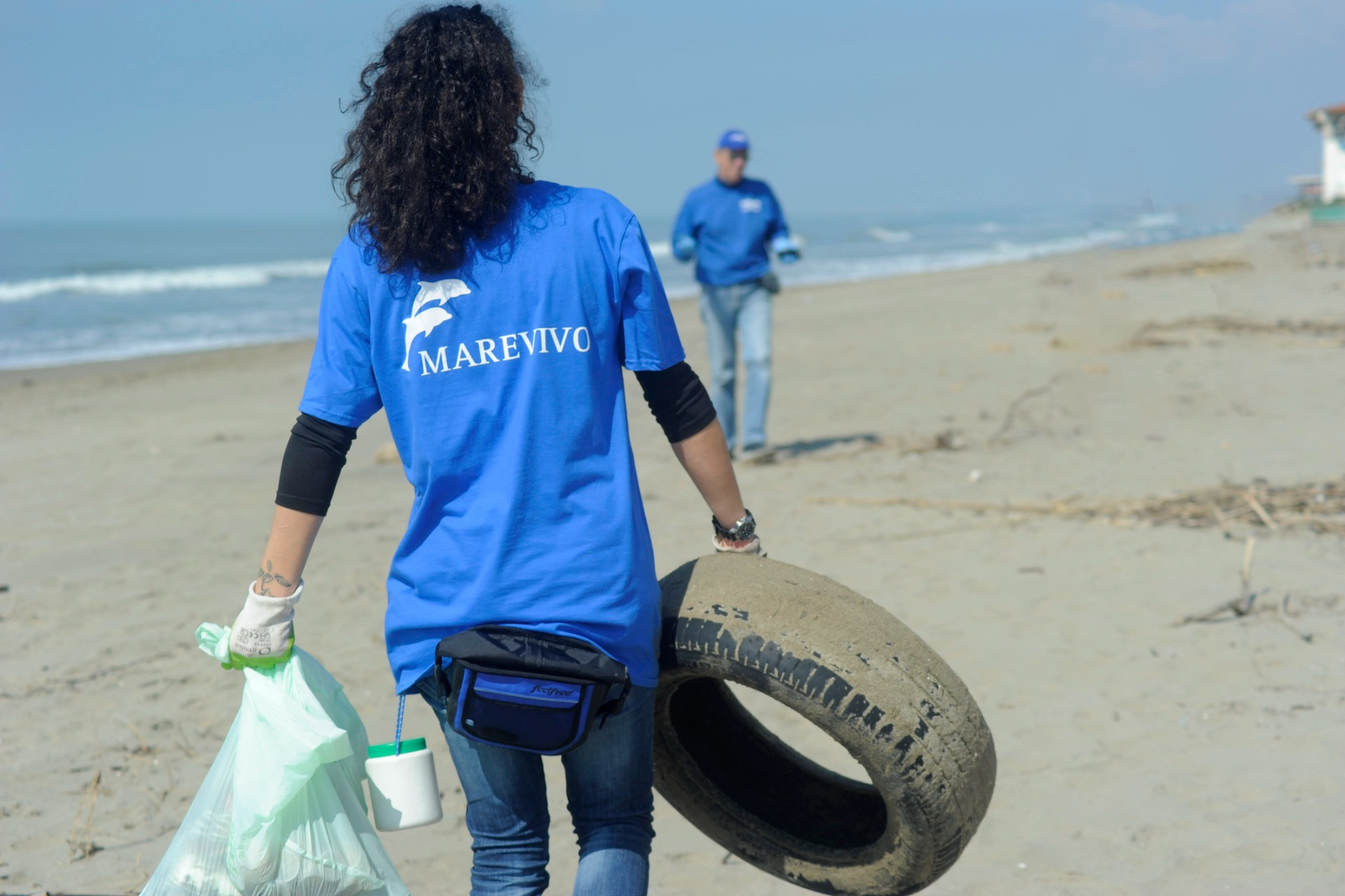 Volontariato green: una volontaria pulisce la spiaggia