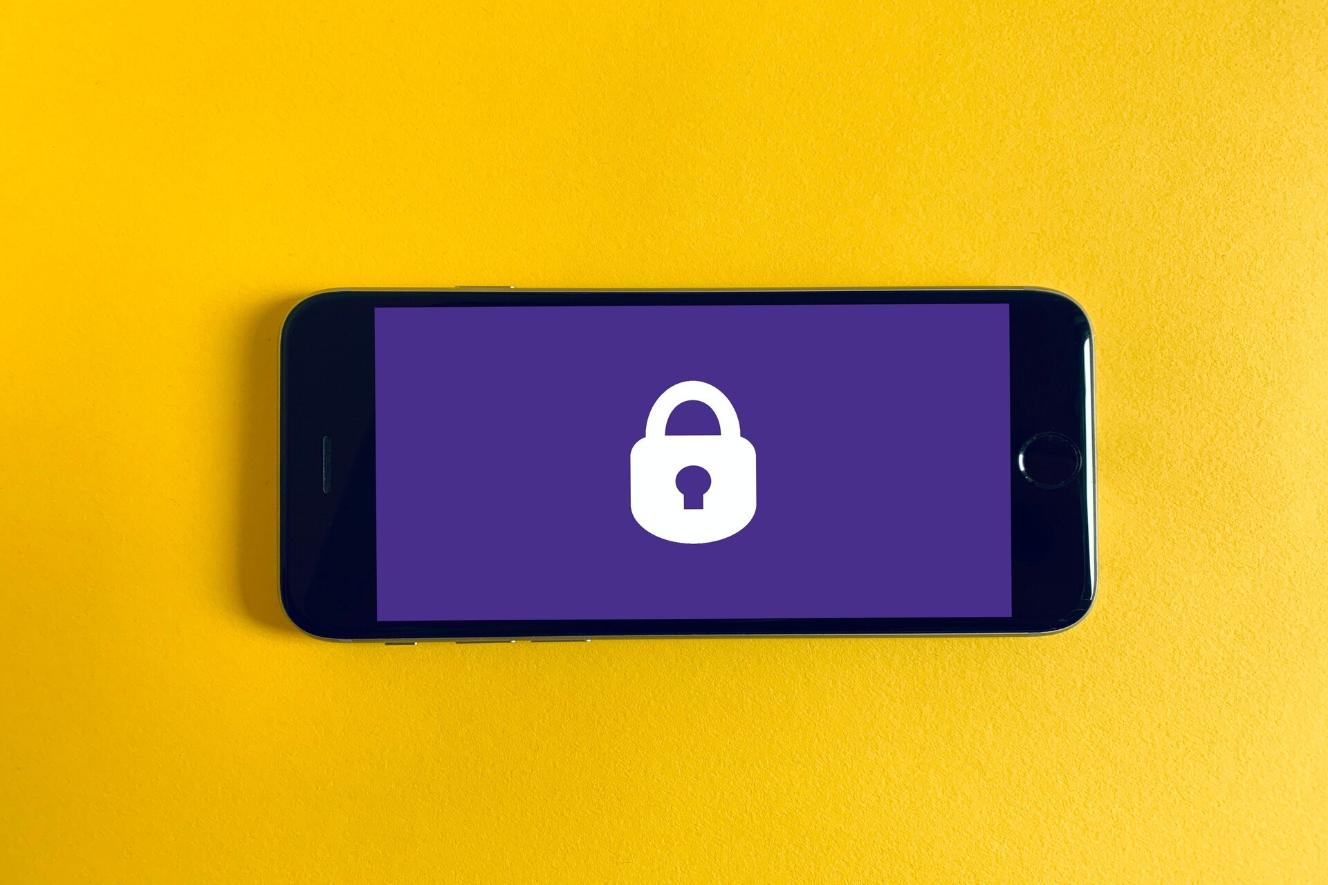 Futuro del lavoro: un iPhone su sfondo giallo, con un blocco lucchetto, simboleggia la sicurezza nel lavoro grazie all'intelligenza artificiale che proteggerà i dati e le informazioni sensibili dei prestatori d’opera