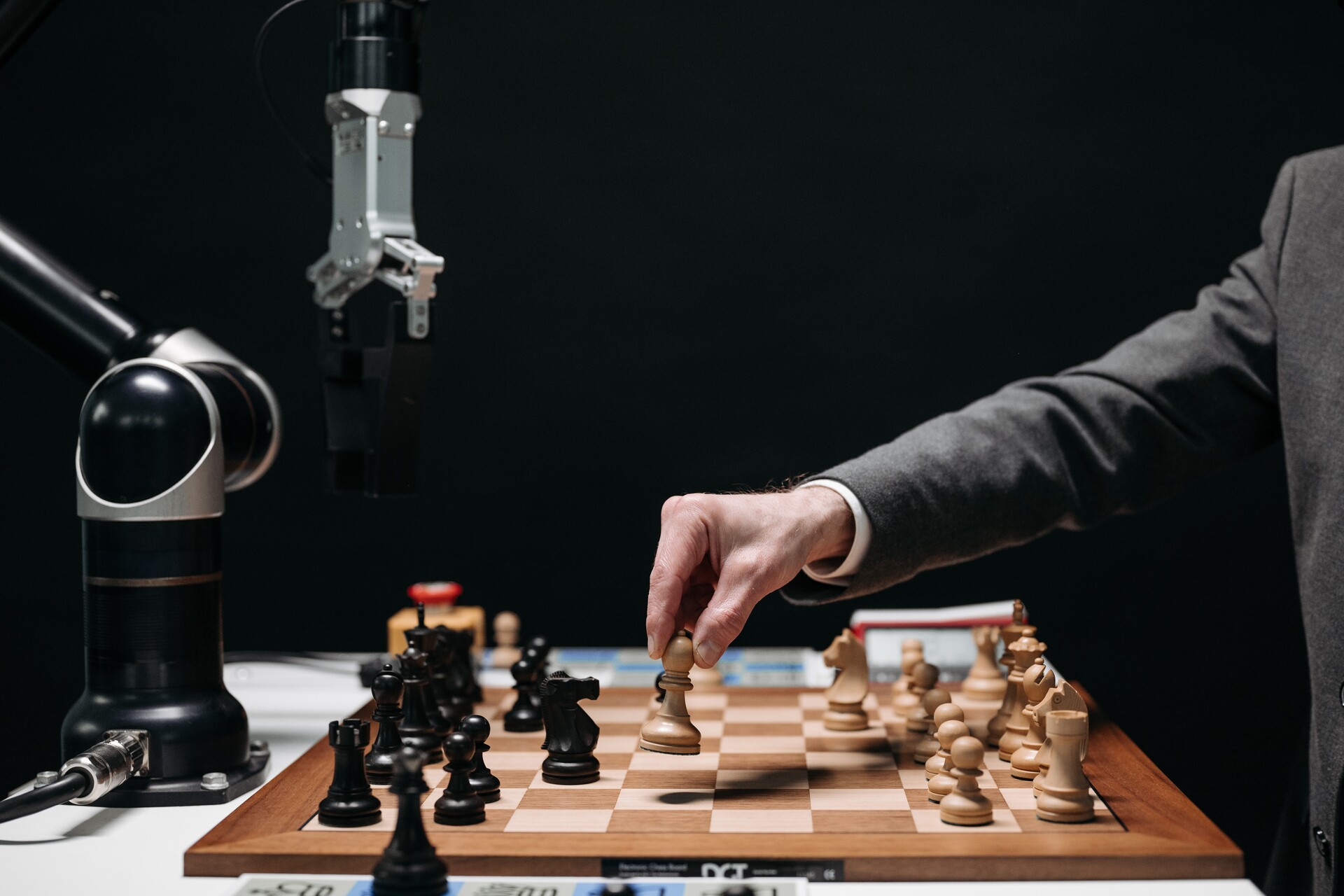 Futuro del lavoro: un uomo si scontra con una mano robotica in una partita di scacchi, un'interessante combinazione tra intelligenza umana e artificiale nel gioco strategico più antico e cerebrale del mondo